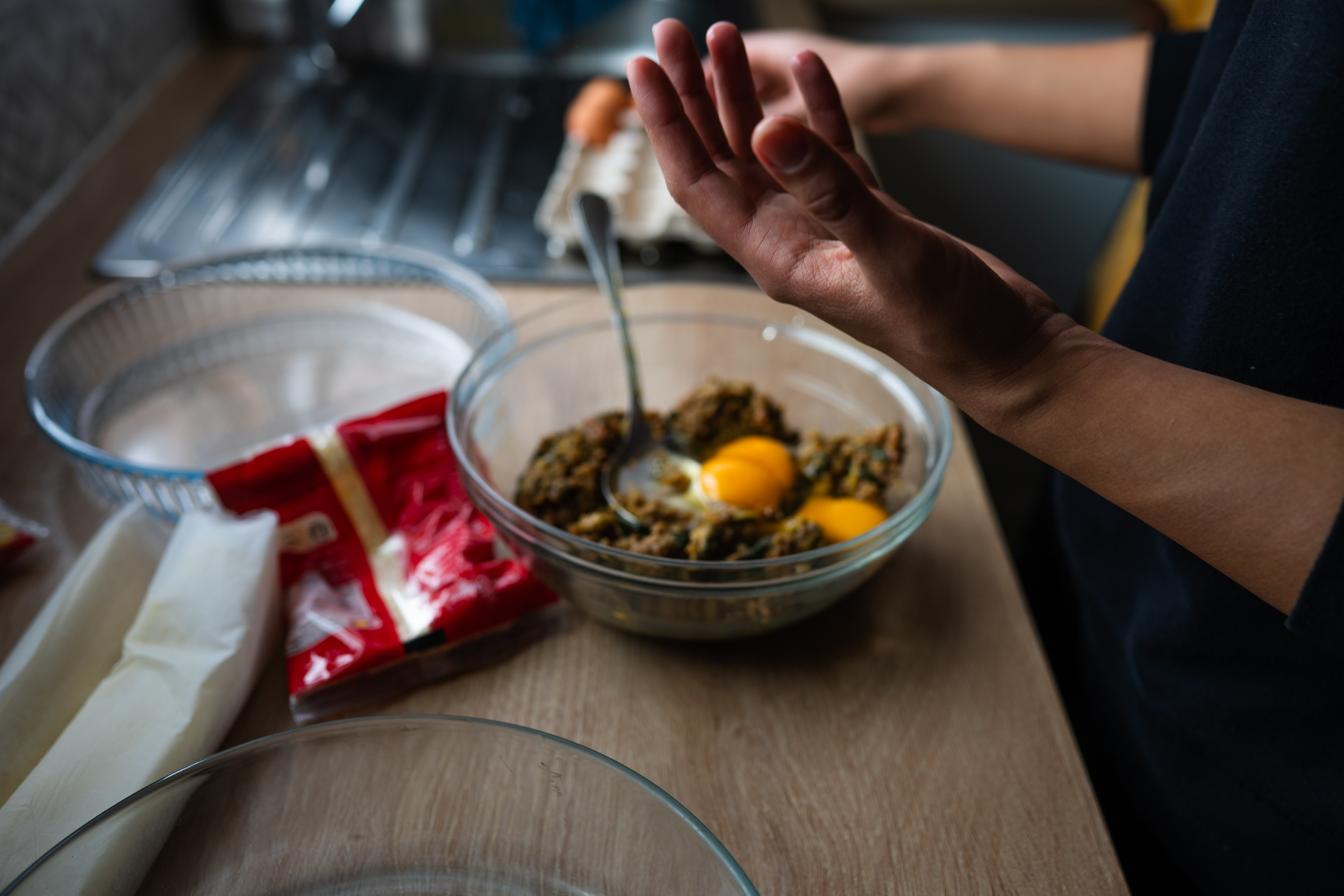 Hands preparing food at a kitchen counter.
