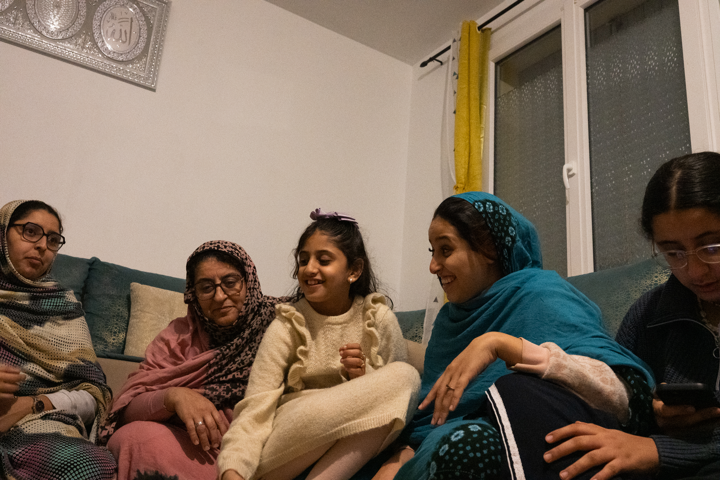 Women and children gathered on a sofa.